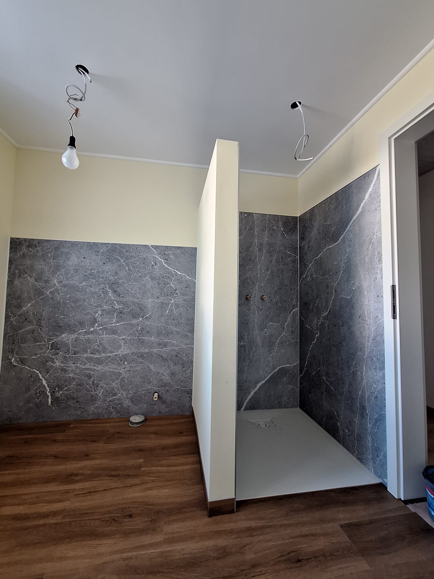 Badezimmer mit Trockenbau-Trennwand und Wandpaneelen in Marmoroptik